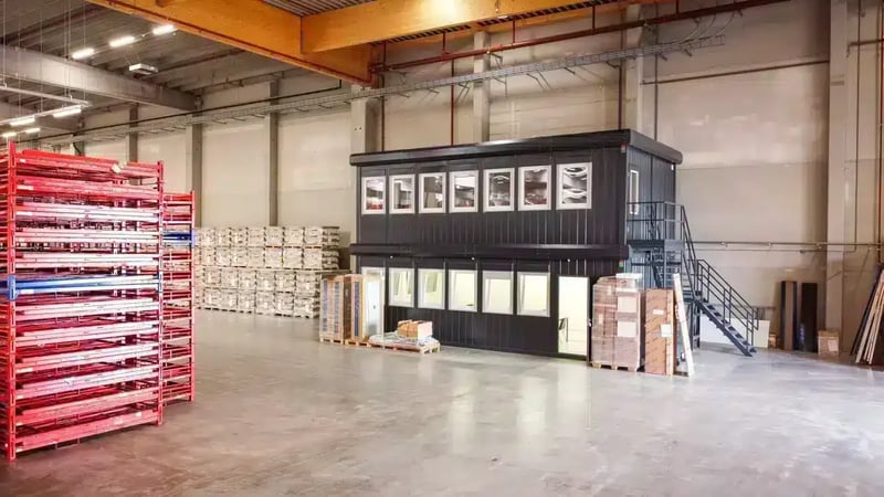 Klein kantoor van modulaire units gebouwd in een loods